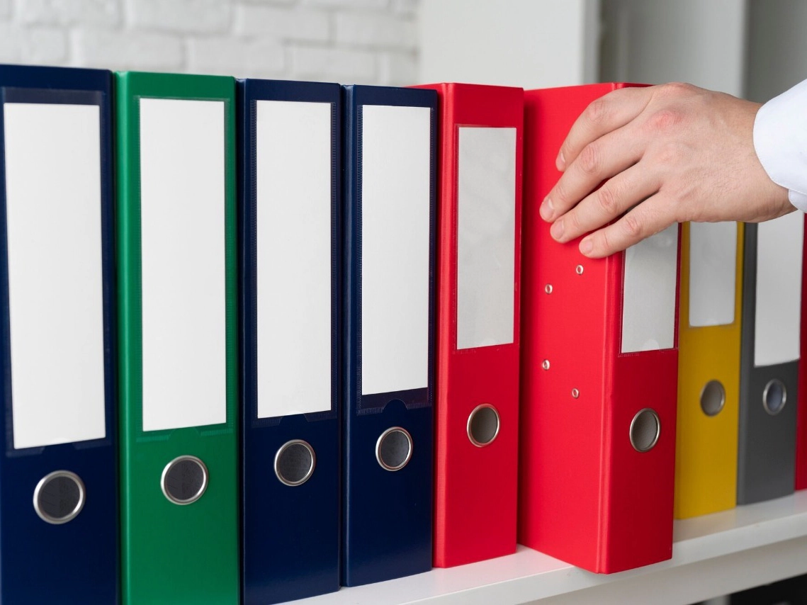 Raccoglitori colorati di un archivio contabile allineati su uno scaffale