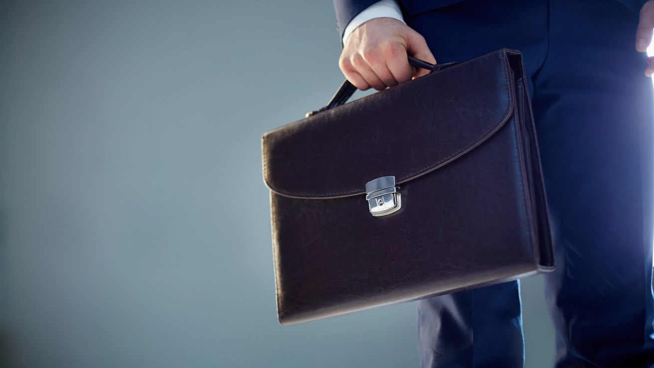 Un professionista in abito con la sua borsa da lavoro