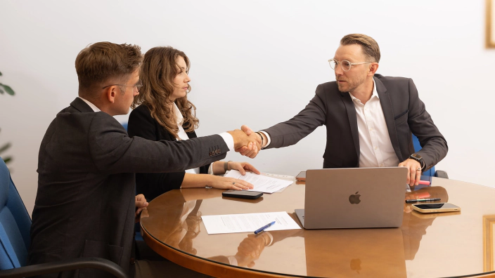 Stretta di mano al tavolo riunioni dello studio Slovenia Consulting a Nova Gorica