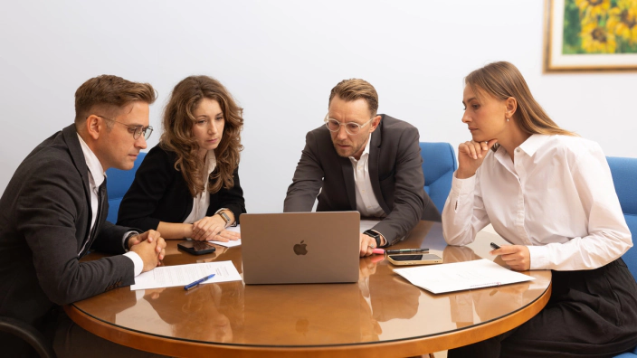 Il team di Slovenia Consulting esamina una pratica al portatile nello studio di Nova Gorica